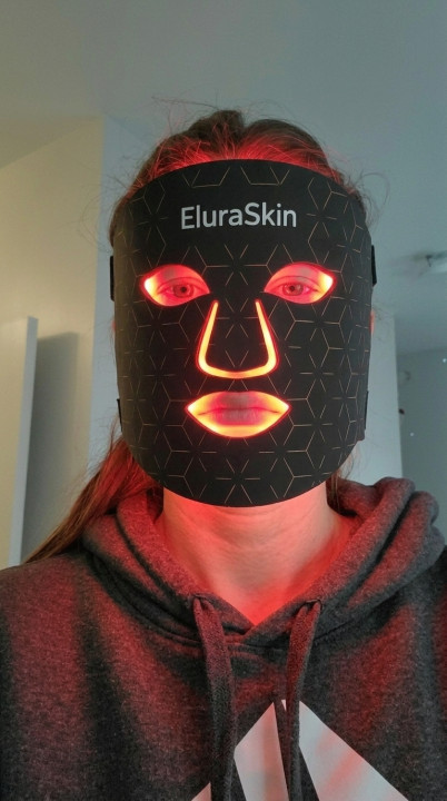 Customer Diana wearing the black EluraSkin mask, lit red